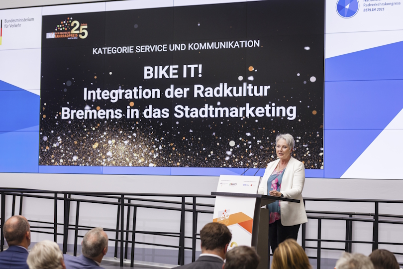 Eine Rednerin spricht auf der Bühne zur Initiative BIKE IT!. Eine Rednerin spricht auf der Bühne zur Initiative BIKE IT!.
