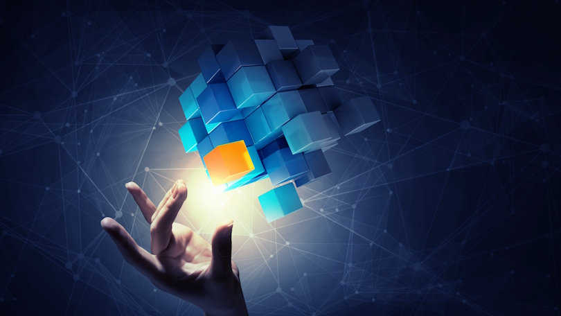 Eine Hand nähert sich einem orangefarbenen Würfel, der sich aus einer größeren Gruppe von blauen Würfeln herausgelöst hat. Im Hintergrund sind zahlreiche Punkte zu sehen, die durch Linien miteinander verbunden sind. Eine Hand nähert sich einem orangefarbenen Würfel, der sich aus einer größeren Gruppe von blauen Würfeln herausgelöst hat. Im Hintergrund sind zahlreiche Punkte zu sehen, die durch Linien miteinander verbunden sind.