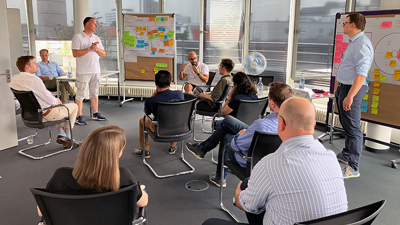 Menschen in einem Raum arbeiten an einem Flipchart Menschen in einem Raum arbeiten an einem Flipchart