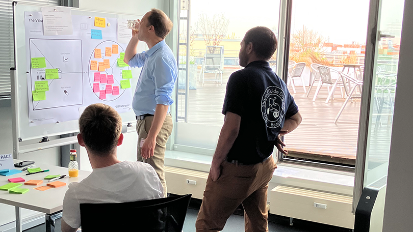 Menschen in einem Raum arbeiten an einem Flipchart Menschen in einem Raum arbeiten an einem Flipchart