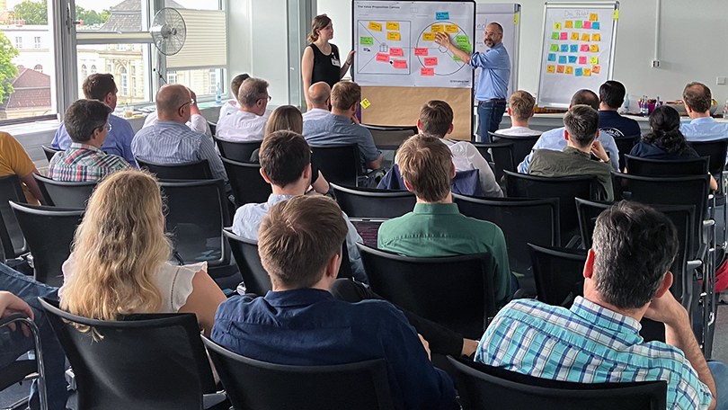 Menschen in einem Raum arbeiten an einem Flipchart Menschen in einem Raum arbeiten an einem Flipchart