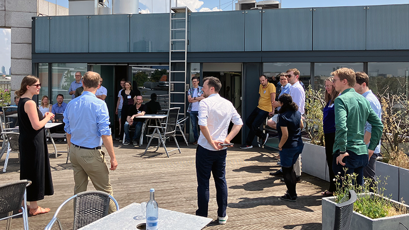 Menschen in stehen beim einem Get-together auf einer sonnigen Dachterrasse Menschen in stehen beim einem Get-together auf einer sonnigen Dachterrasse