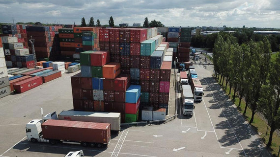 Zum Artikel Lagerplatz von Containern mit lkws im vordergrund