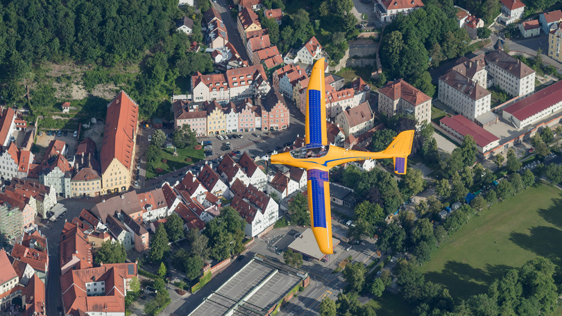 Luftbildaufnahme von einer stadt und im vordergrund segelflugzeug Luftbildaufnahme von einer stadt und im vordergrund segelflugzeug