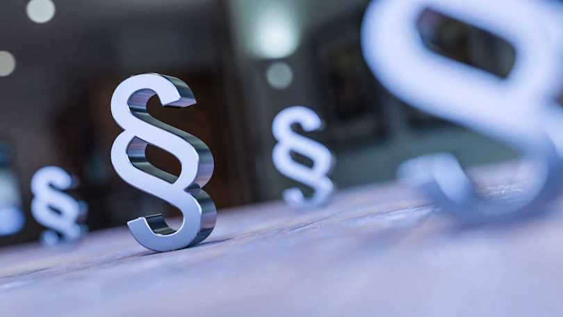 Einzelne plastische, dreidimensionale Paragraphen-Symbole stehen verschieden entfernt von der Kamera auf einer Fläche und werden unterschiedlich scharf dargestellt. Einzelne plastische, dreidimensionale Paragraphen-Symbole stehen verschieden entfernt von der Kamera auf einer Fläche und werden unterschiedlich scharf dargestellt.