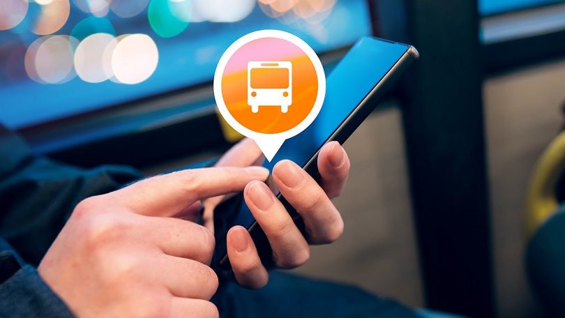 eine Hand hält ein Smartphone und bedient darauf eine Bus-App eine Hand hält ein Smartphone und bedient darauf eine Bus-App