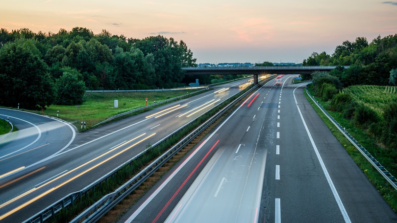 Blick von einer Brücke auf eine Autobahn bei Abenddämmerung Blick von einer Brücke auf eine Autobahn bei Abenddämmerung