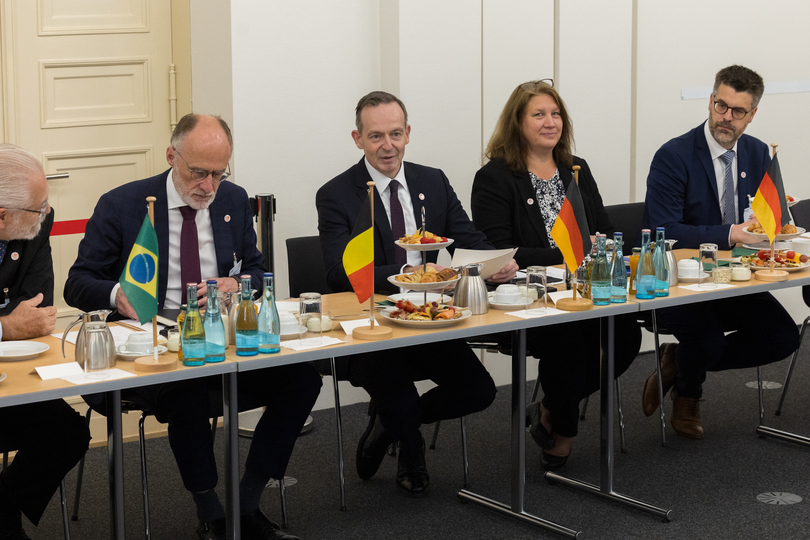 Volker Wissing sitzt beim E-Fuels Dialogue an einem Tisch neben Vertretern aus Belgien und Brasilien, auf dem Tisch stehen die Flaggen der Länder. Volker Wissing sitzt beim E-Fuels Dialogue an einem Tisch neben Vertretern aus Belgien und Brasilien, auf dem Tisch stehen die Flaggen der Länder.