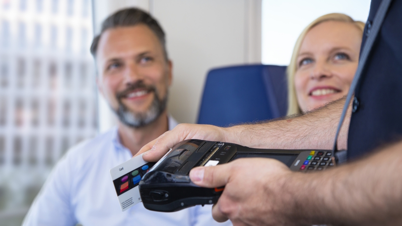 Ein Kontrolleur prüft das Ticket von Fahrgästen Ein Kontrolleur prüft das Ticket von Fahrgästen