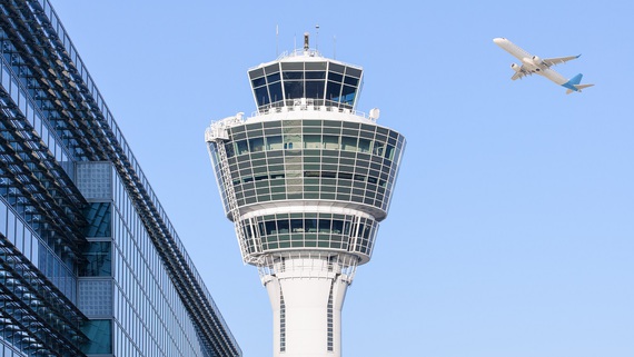 Ein Flugzeug fliegt an einem Flughafen-Tower vorbei Ein Flugzeug fliegt an einem Flughafen-Tower vorbei