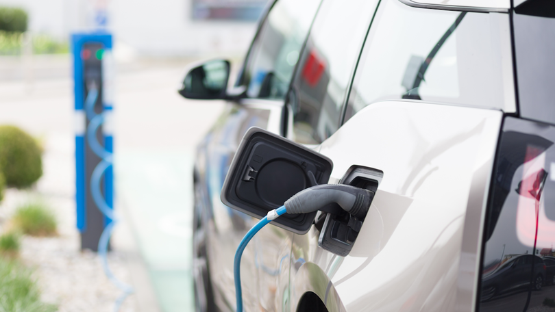 Power supply for electric car charging. Electric car charging station. Close up of the power supply plugged into an electric car being charged. Power supply for electric car charging. Electric car charging station. Close up of the power supply plugged into an electric car being charged.