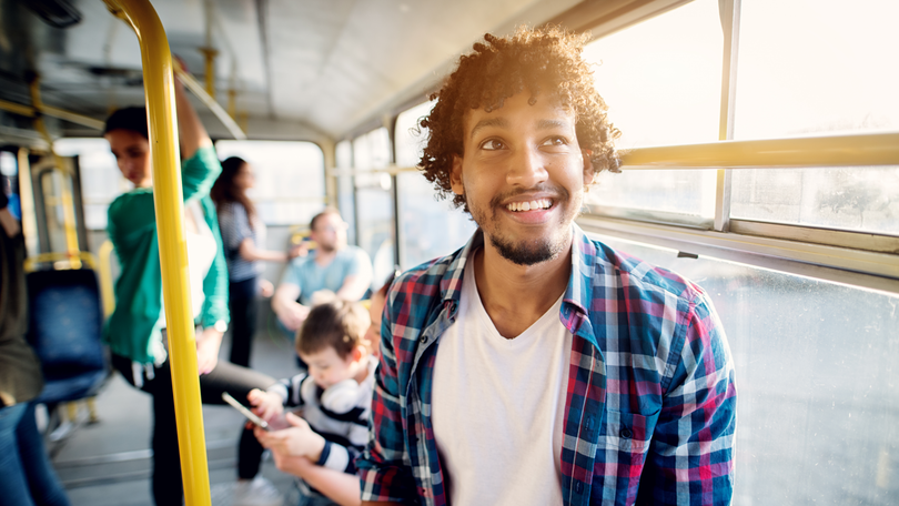 Ein lächelnder junger Mann in einem Bus Ein lächelnder junger Mann in einem Bus