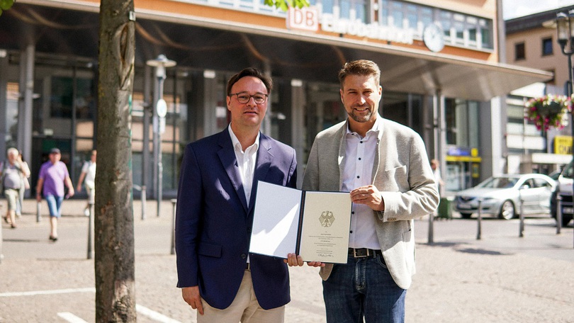 Staatssekretär Oliver Luksic neben dem Oberbürgermeister von Saarbrücken, Uwe Conradt, bei der Übergabe des Förderbescheides vor dem Hauptbahnhof Saarbrücken Staatssekretär Oliver Luksic neben dem Oberbürgermeister von Saarbrücken, Uwe Conradt, bei der Übergabe des Förderbescheides vor dem Hauptbahnhof Saarbrücken
