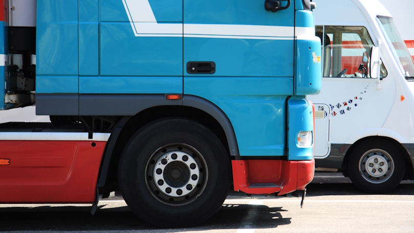 Seitliche Ansicht des Führerhauses eines Lkw, der neben weiteren Fahrzeugen parkt. Seitliche Ansicht des Führerhauses eines Lkw, der neben weiteren Fahrzeugen parkt.