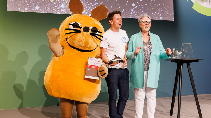 Auf dem Foto: Die Maus bekam den Preis für die fahrradfreundlichste Persönlichkeit des Jahres 2024 von der Vorsitzenden der AGFS NRW Christine Fuchs überreicht Auf dem Foto: Die Maus bekam den Preis für die fahrradfreundlichste Persönlichkeit des Jahres 2024 von der Vorsitzenden der AGFS NRW Christine Fuchs überreicht
