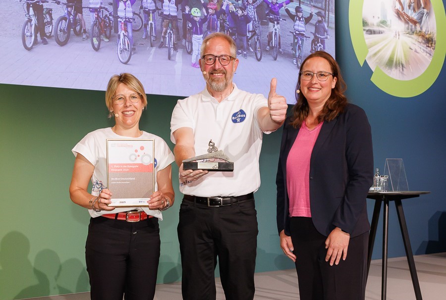 Auf dem Foto zu sehen - zwei Frauen und ein Mann in der Mitte auf einer Bühne: Dem Gewinner der Kategorie Ehrenamt überreichte Britta Sieper, Geschäftsführerin PUKY GmbH & Co. KG und ZIV-Vorstandsmitglied, den Preis Auf dem Foto zu sehen - zwei Frauen und ein Mann in der Mitte auf einer Bühne: Dem Gewinner der Kategorie Ehrenamt überreichte Britta Sieper, Geschäftsführerin PUKY GmbH & Co. KG und ZIV-Vorstandsmitglied, den Preis